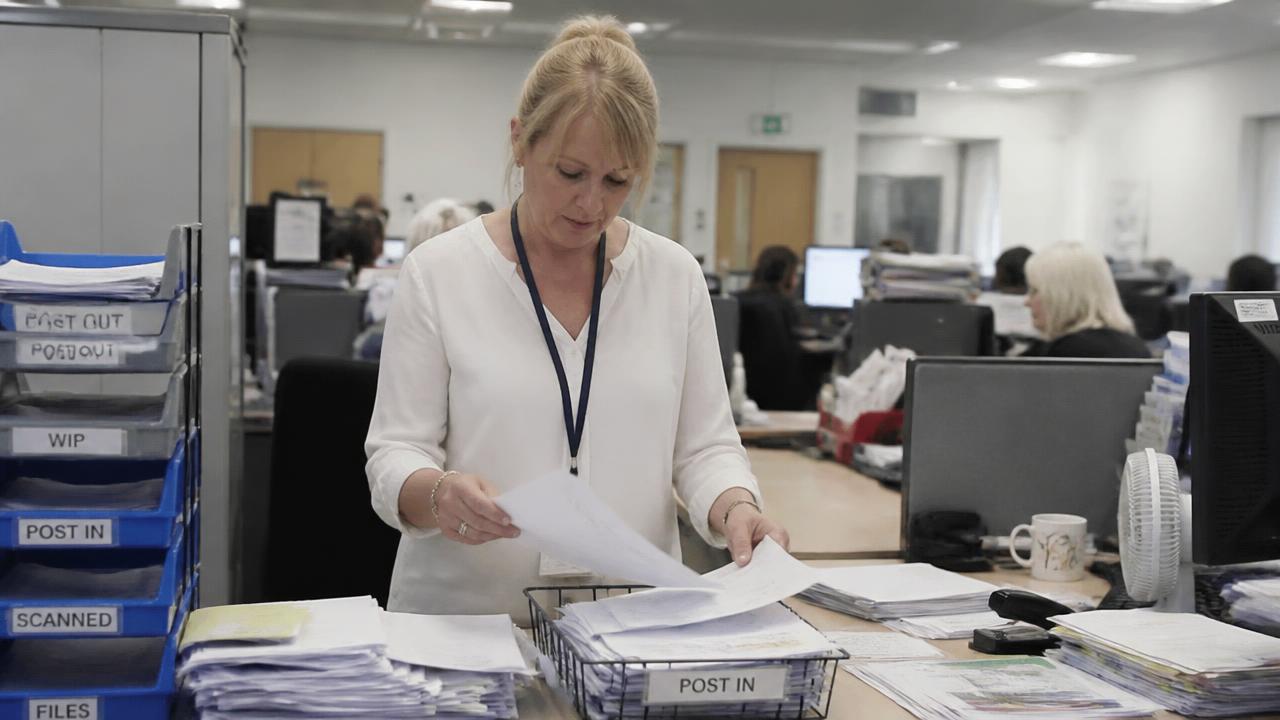 Administrative team sorting documents and correspondence in a bright office